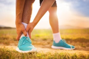 Male runner with blue shoes and ankle pain