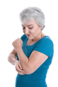 older woman has joint pain in elbow