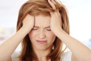 Woman with headache in need of migraine relief treatment