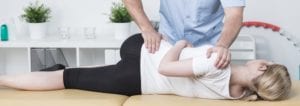 Young woman receiving pain management chiropractic adjustment.